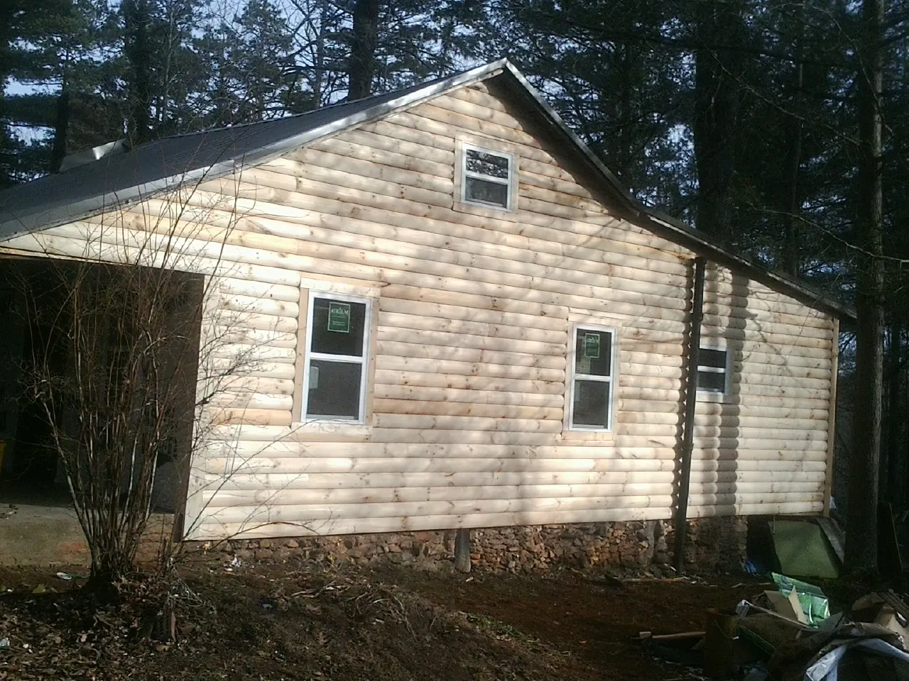 New log siding and dark metal roofing on a gable end in Blakely
