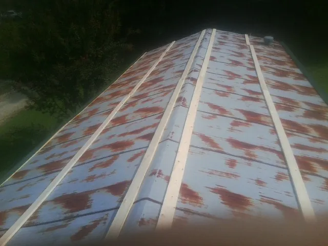 Rusted metal roof panels with new wood purlins before replacement — Storm Damage Roof Repair in Blakely by Roofing Brothers
