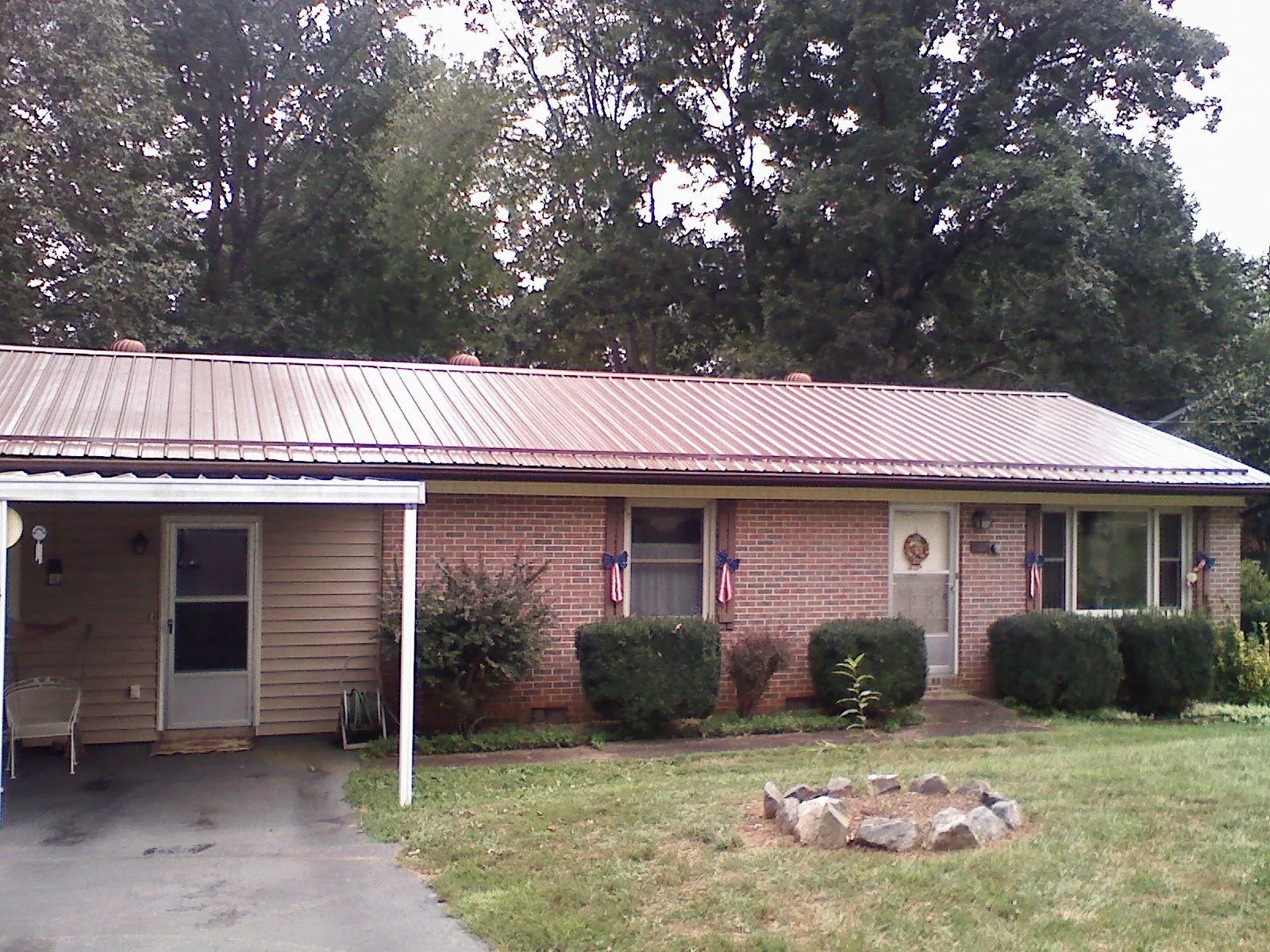 Bronze metal roof and carport on a brick ranch home — Roof Repair work by our crew in Blakely